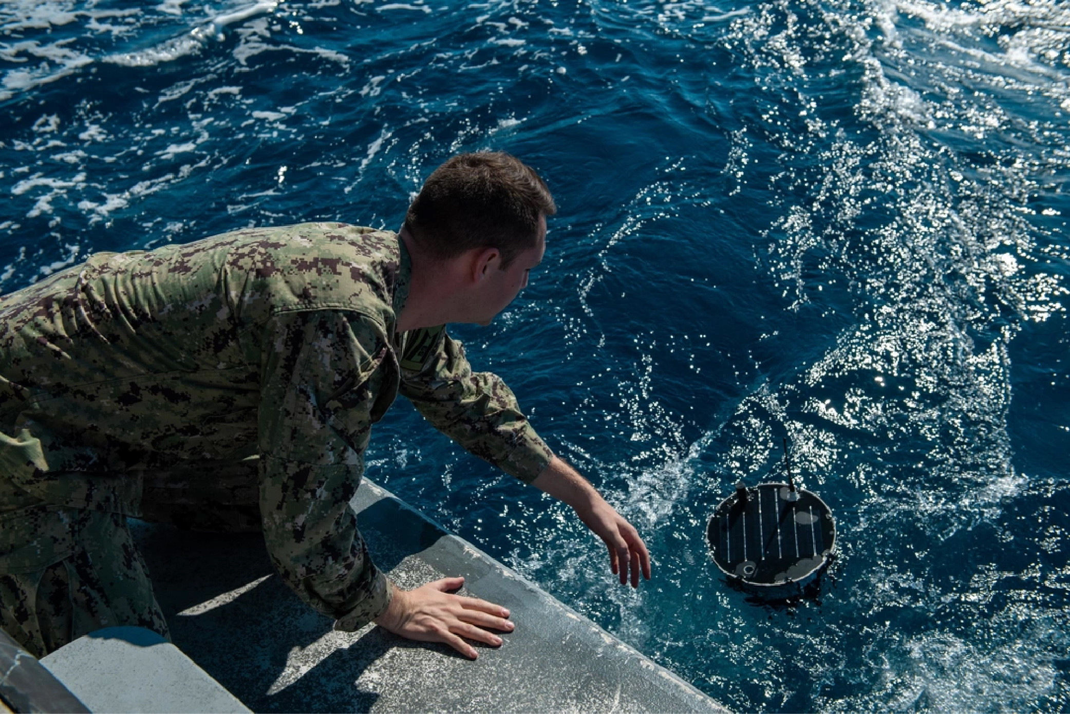 Solder lowers a floating sensor that collects maritime environmental data.