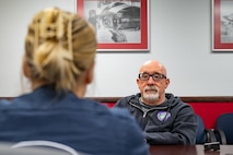 U.S. Air Force Senior Airman Lauren Clevenger, left, a public affairs specialist assigned to the Thunderbirds, briefs Hometown Hero participant, Michael Patterson, on the itinerary for the day on April 4, 2025 at Nellis Air Force Base, Nevada.