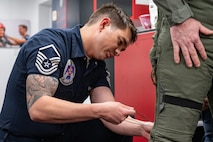 U.S. Air Force Master Sgt. Corey Harrison, flight chief and aircrew flight equipment specialist assigned to the Thunderbirds, secures gear on Michael Patterson, a participant of Hometown Hero, on April 4, 2025 at Nellis Air Force Base, Nevada.