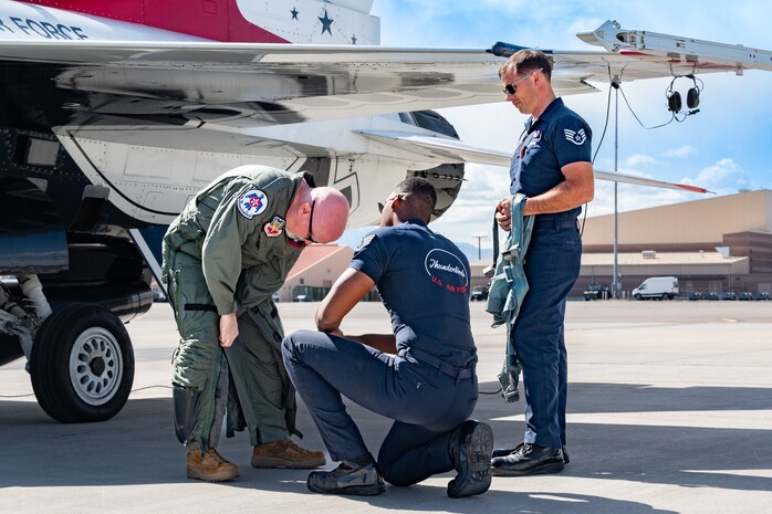 From left to right, Michael Patterson, Hometown Hero candidate, gears up before his flight with assistance from U.S. Air Force Staff Sgt. William Solomon, #8 assistant dedicated crew chief and Ssgt Jacob Jeschke, #8 dedicated crew chief, both assigned to the Thunderbirds, on April 4, 2025 at Nellis Air Force Base, Nevada.