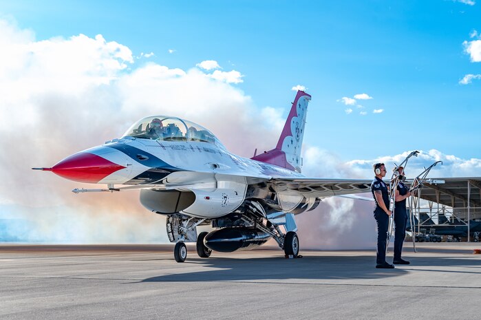 U.S. Air Force dedicated crew chiefs assigned to the USAF Air Demonstration Squadron Thunderbirds, hold jet step ladders while waiting for an F-16 returning back from a Hometown Hero flight to come to a complete stop on April 4, 2025, at Nellis Air Force Base, Nevada.