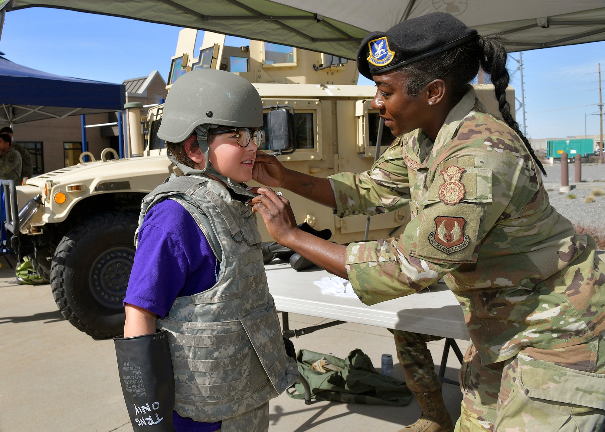 An Airman adjusts the chin strap of a helmet on a student.