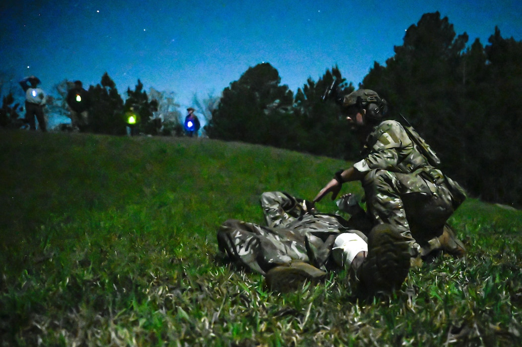 Explosive ordnance disposal (EOD) technicians and 19th Medical Group personnel conduct tactical combat casualty care (TCCC) and medical evacuation procedures during a joint EOD field training exercise at Camp Joseph T. Robinson, Arkansas, April 9, 2025. This joint training was designed to simulate real-world combat scenarios involving both explosive threats and medical emergencies.