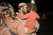 U.S. Air Force Senior Airman Payton Cobb, assigned to the 820th Rapid Engineering Deployable Heavy Operations Repair Squadron Engineer Squadron, reunites with his family during a redeployment at Nellis Air Force Base, Nevada, April 2, 2025.