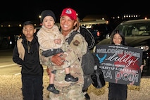 U.S. Air Force Senior Airman Elvin Dom, assigned to the 820th Rapid Engineering Deployable Heavy Operations Repair Squadron Engineer Squadron, reunites with his family during a redeployment at Nellis Air Force Base, Nevada, April 2, 2025.