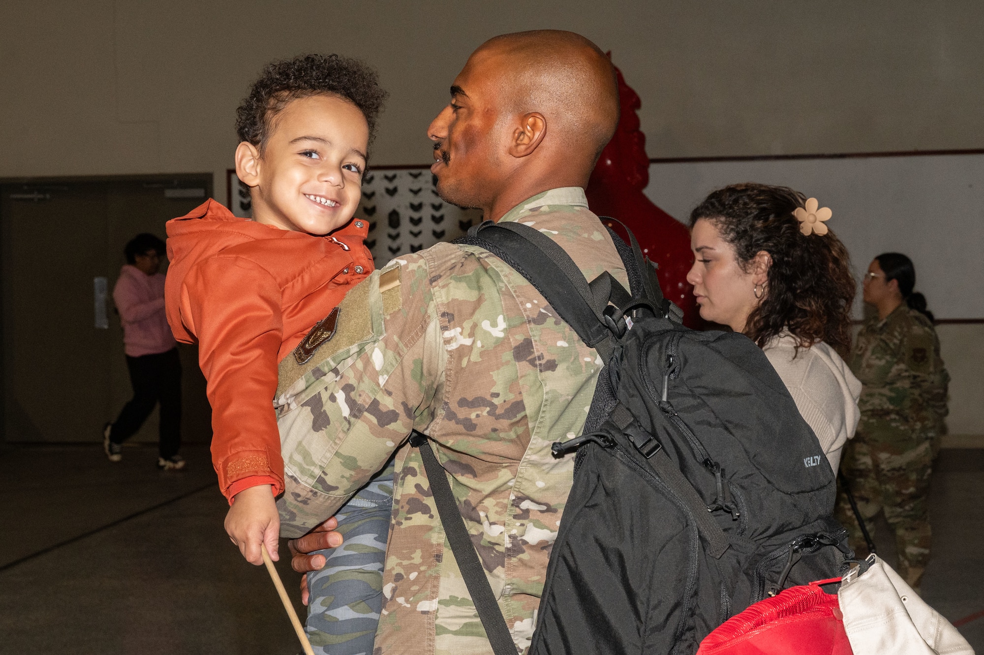 U.S. Air Force Senior Airman Christopher Gonzalez Encarnacion, assigned to the 820th Rapid Engineering Deployable Heavy Operations Repair Squadron Engineer Squadron, holds his son during a redeployment at Nellis Air Force Base, Nevada, April 2, 2025.
