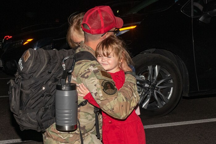 U.S. Air Force Staff Sgt. Robert Worrell, assigned to the 820th Rapid Engineering Deployable Heavy Operations Repair Squadron Engineer Squadron, reunites with his family during a redeployment at Nellis Air Force Base, Nevada, April 2, 2025.