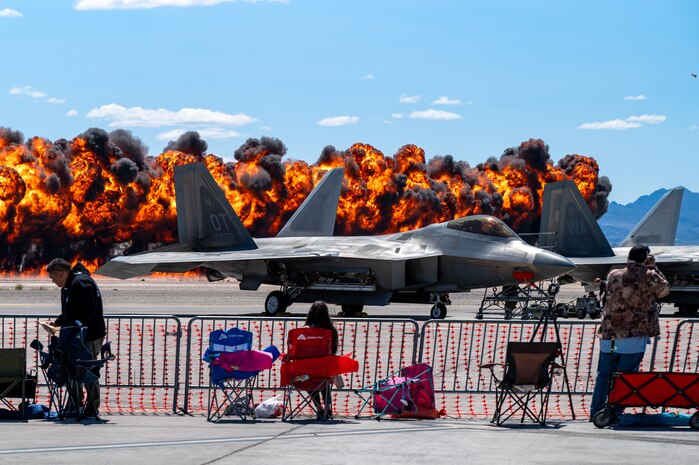 An explosion is simulated behind a U.S. Air Force F-22 Raptor aircraft during the Commemorative Air Force Southern California (CAF SoCal) Wing Aviation Nation 2025 performance at Nellis Air Force Base, Nevada, April 4, 2025.