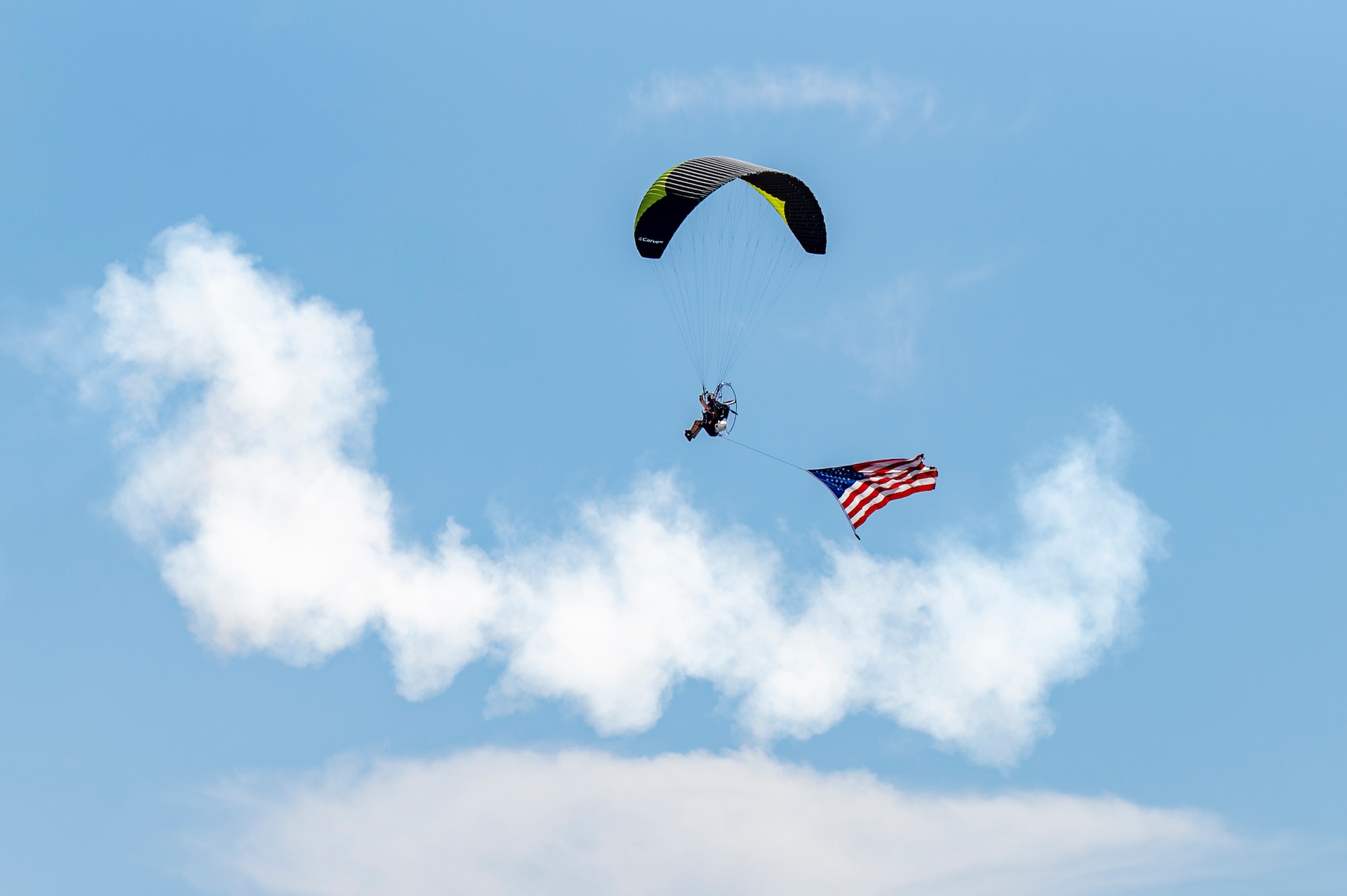 A paramotor parachutist carrying the United States flag performs an aerial demonstration during Aviation Nation 2025 at Nellis Air Force Base, Nevada, April 5, 2025.
