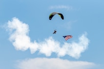 A paramotor parachutist carrying the United States flag performs an aerial demonstration during Aviation Nation 2025 at Nellis Air Force Base, Nevada, April 5, 2025.