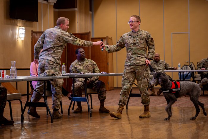 U.S. Air Force Lt. Col. Daniel Blomberg, left, 35th Civil Engineering Squadron commander, hands the microphone over to U.S. Air Force Maj. David Parks, 35th Operational Medical Readiness Squadron director of psychological health, during a Permanent Change of Station (PCS) and housing town hall.