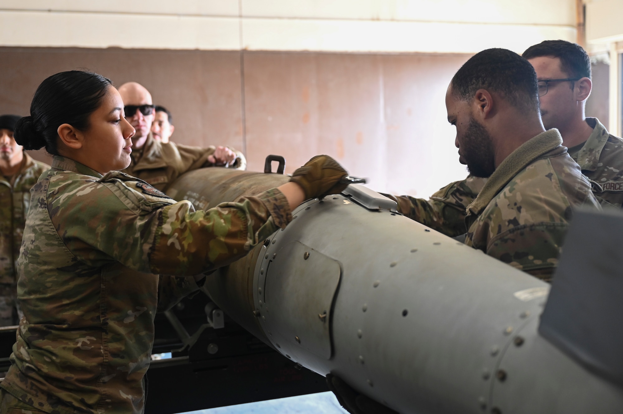 Airmen from the 8th Maintenance Squadron Munitions Flight practice installing a tail fin on a training munition.