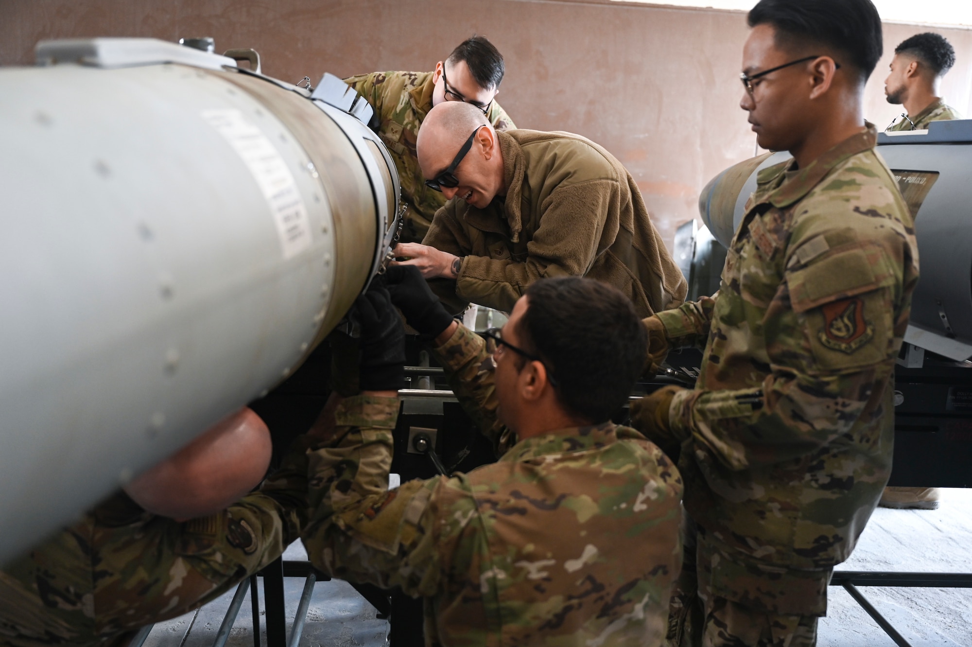 Airmen from the 8th Maintenance Squadron Munitions Flight practice installing panels on a training munition.