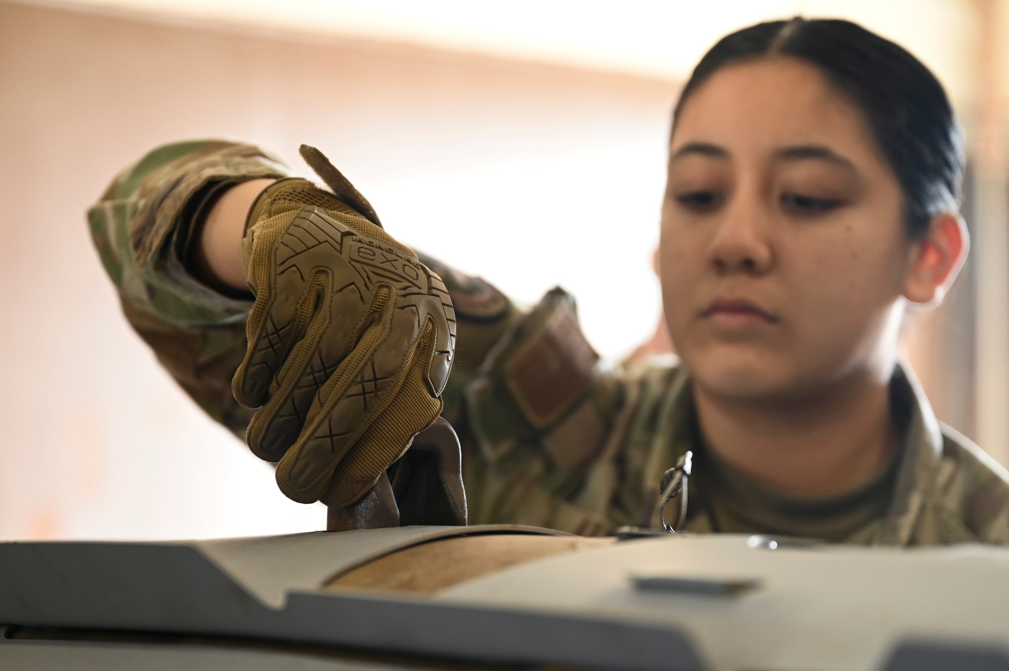 Senior Airman Vanessa Alvarado, 8th Maintenance Squadron Munitions Flight precision guided munitions crew chief, tightens a suspension lug on a training munition.