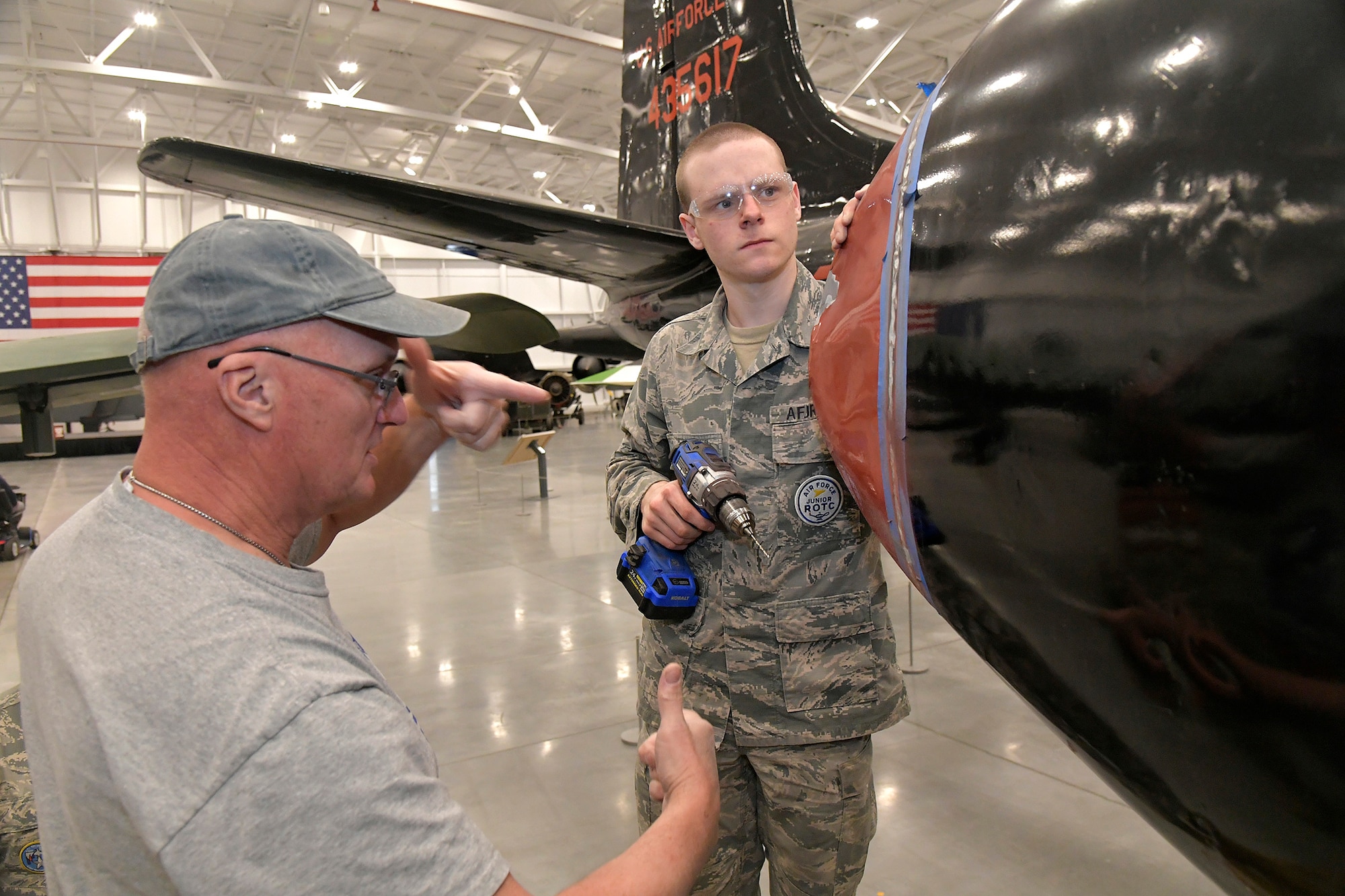 (From left) Darrell Gronau, aviation maintenance instructor, teaches proper riveting techniques to Cash Bowerbank, an ROTC Utah Military Academy student, on display aircraft fuselage skin March 11, 2025, at Hill Air Force Base, Utah. Local students learn, train and develop real-world airframe work skills by participating in local academic partnerships with the Hill Aerospace Museum’s established curriculum at the aircraft restoration facility. (U.S. Air Force photo by Todd Cromar)