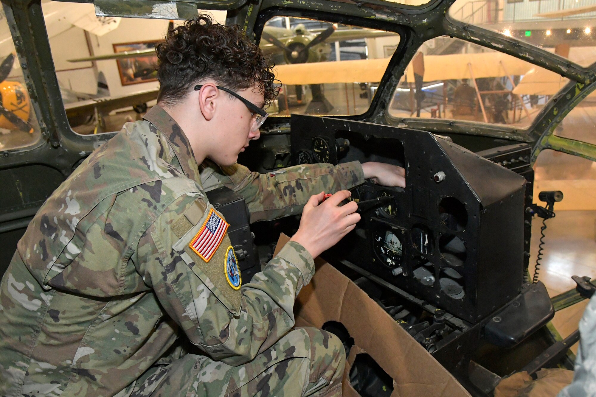 Preston Fenton, ROTC Utah Military Academy student, removes gauges from the instrument panel of a display B-29 March 11, 2025, at Hill Air Force Base, Utah. Local students learn, train and develop real-world airframe work skills by participating in local academic partnerships with the Hill Aerospace Museum’s established curriculum at the aircraft restoration facility. (U.S. Air Force photo by Todd Cromar)