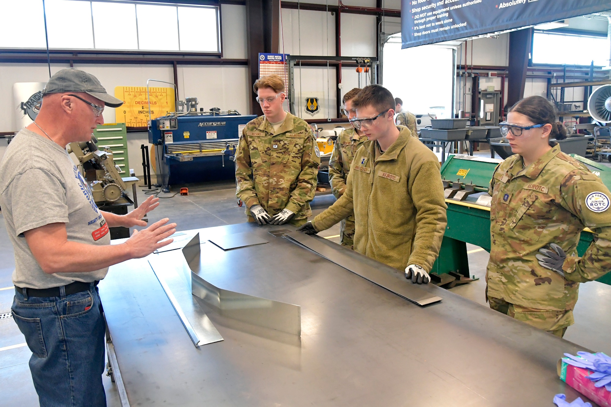 (From left) Darrell Gronau, aviation maintenance instructor, teaches sheet metal skills to ROTC Utah Military Academy students Max Richins, Cole Duffield, Lucas Innocenzi and Alexandra Hyde March 11, 2025, at Hill Air Force Base, Utah. Local students learn, train and develop real-world airframe work skills by participating in local academic partnerships with the Hill Aerospace Museum’s established curriculum at the aircraft restoration facility. (U.S. Air Force photo by Todd Cromar)