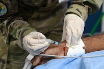 U.S. Air Force Maj. Alisha Young, 433rd Aeromedical Staging Squadron critical care air transport team physician, draws an arterial blood gas sample from a patient at the emergency room inside the Georgetown Public Hospital during the Lesser Antilles Medical Assistance Team mission in Georgetown, Guyana, April 3, 2025.