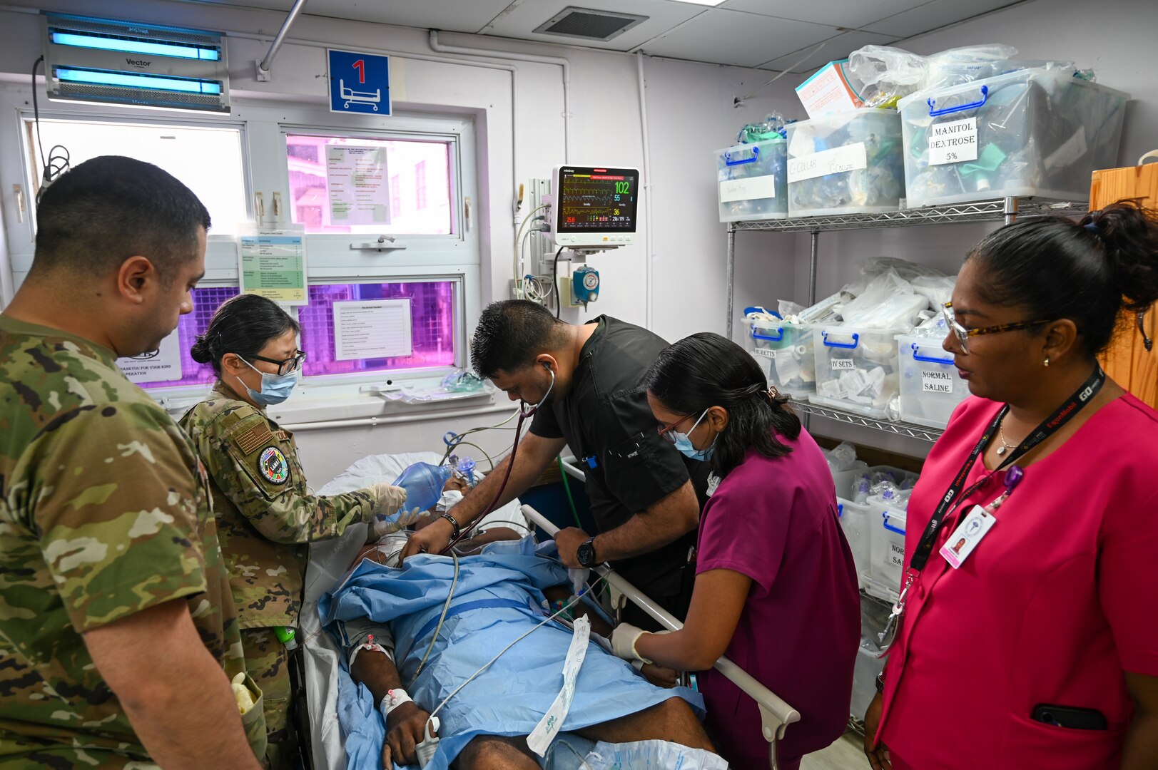 U.S. Air Force Maj. Alisha Young, 433rd Aeromedical Staging Squadron critical care air transport team physician, and U.S. Air Force Tech. Sgt. Rodrigo Salinas, 433rd ASTS medical technician, provides assistance to doctors and healthcare professionals during an emergency at the Georgetown Public Hospital during the Lesser Antilles Medical Assistance Team mission in Georgetown, Guyana, April 3, 2025.