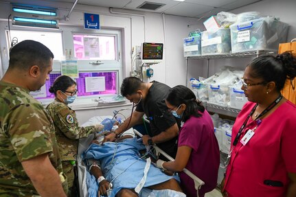 U.S. Air Force Maj. Alisha Young, 433rd Aeromedical Staging Squadron critical care air transport team physician, and U.S. Air Force Tech. Sgt. Rodrigo Salinas, 433rd ASTS medical technician, provides assistance to doctors and healthcare professionals during an emergency at the Georgetown Public Hospital during the Lesser Antilles Medical Assistance Team mission in Georgetown, Guyana, April 3, 2025.