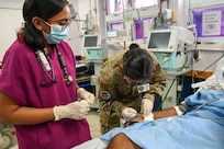 U.S. Air Force Maj. Alisha Young, 433rd Aeromedical Staging Squadron critical care air transport team physician, teaches an internal medicine intern how to draw an arterial blood gas sample from a patient at the emergency room inside the Georgetown Public Hospital during the Lesser Antilles Medical Assistance Team mission in Georgetown, Guyana, April 3, 2025.