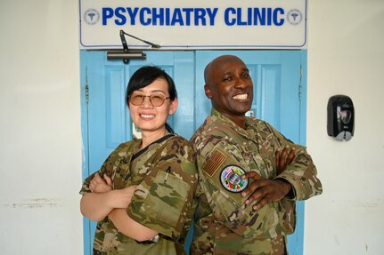 U.S. Air Force Maj. Wan Chen, 433rd Aeromedical Staging Squadron psychiatric nurse practitioner, and U.S. Air Force Maj. Quinton Murry, 433rd ASTS psychiatric nurse practitioner, pose for a photo outside the psychiatry clinic at the Georgetown Public Hospital during the Lesser Antilles Medical Assistance Team mission in Georgetown, Guyana, April 7, 2025.