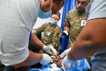 U.S. Air Force Maj. Alisha Young, 433rd Aeromedical Staging Squadron critical care air transport team physician, and U.S. Air Force Tech. Sgt. Rodrigo Salinas, 433rd ASTS medical technician, provides assistance to doctors during a medical procedure at the emergency room inside Georgetown Public Hospital during the Lesser Antilles Medical Assistance Team mission in Georgetown, Guyana, April 2, 2025.