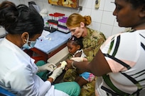 U.S. Air Force Senior Master Sgt. Suzanne Redd, 433rd Aeromedical Staging Squadron senior enlisted leader, and Julia Ann Sarjoo, Georgetown Public Hospital phlebotomist, take blood from a child patient with help from the child’s mother at the pediatric emergency section at Georgetown Public Hospital during the Lesser Antilles Medical Assistance Team mission in Georgetown, Guyana, April 2, 2025.