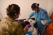 U.S. Air Force Senior Master Sgt. Erin Summers, 433rd Aeromedical Staging Squadron medical technician, and Kimberley Grumble-Munroe, West Demerara Hospital registered nurse, work together to administer multiple sutures on a patient who experienced head trauma in a vehicular accident  at the West Demerara Regional Hospital emergency room during the Lesser Antilles Medical Assistance Team mission in Georgetown, Guyana, April 8, 2025.