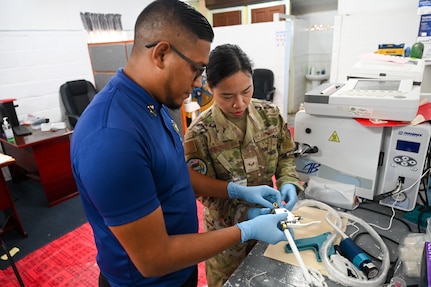 U.S. Air Force Senior Airman Liezel Westmoreland, 433rd Aeromedical Staging Squadron biomedical equipment technician, and Kumar Persaud, Ministry of Health biomedical technician assemble a cryotherapy gun at the West Demerara Regional Hospital during the Lesser Antilles Medical Assistance Team mission in Georgetown, Guyana, April 8, 2025.