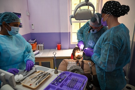 U.S. Air Force Col. Michael Dailey, Air Combat Command Surgeon General reserve expeditionary dentistry consultant, center, U.S. Air Force Master Sgt. Cassie Talley, 302nd Airlift Wing dental technician, right, and Christina Seenarine, Guyanese dental assistant, left, operate on a patient at the Port Mourant Hospital during the Lesser Antilles Medical Assistance Team mission in Port Mourant, Guyana, March 31, 2025.