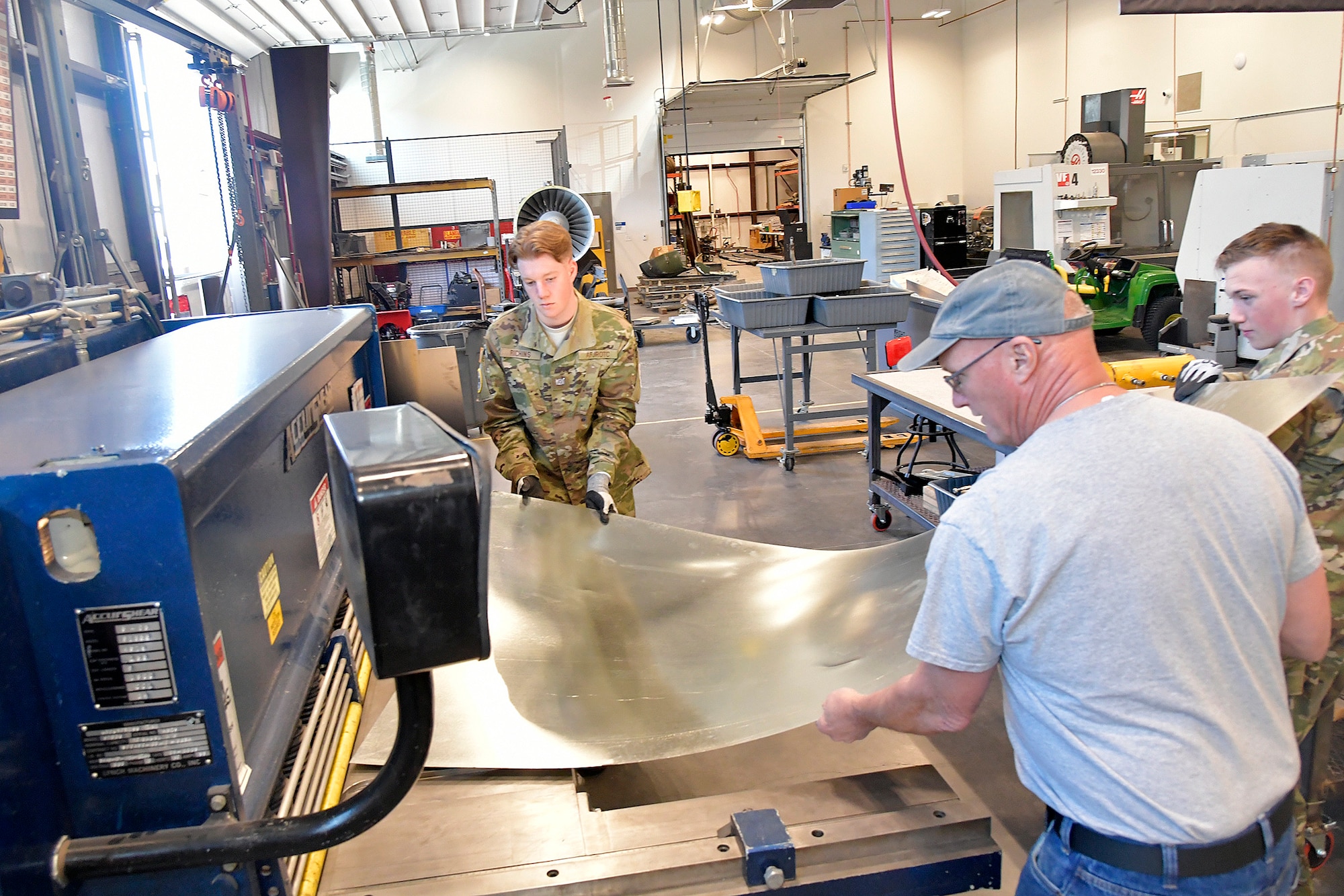 (From left) Max Richins, ROTC Utah Military Academy, Darrell Gronau, aviation maintenance instructor, and Cole Duffield, ROTC Utah Military Academy, cut sheet metal for replacement fuselage skin March 11, 2025, at Hill Air Force Base, Utah. Local students learn, train and develop real-world airframe work skills by participating in local academic partnerships with the Hill Aerospace Museum’s established curriculum at the aircraft restoration facility. (U.S. Air Force photo by Todd Cromar)