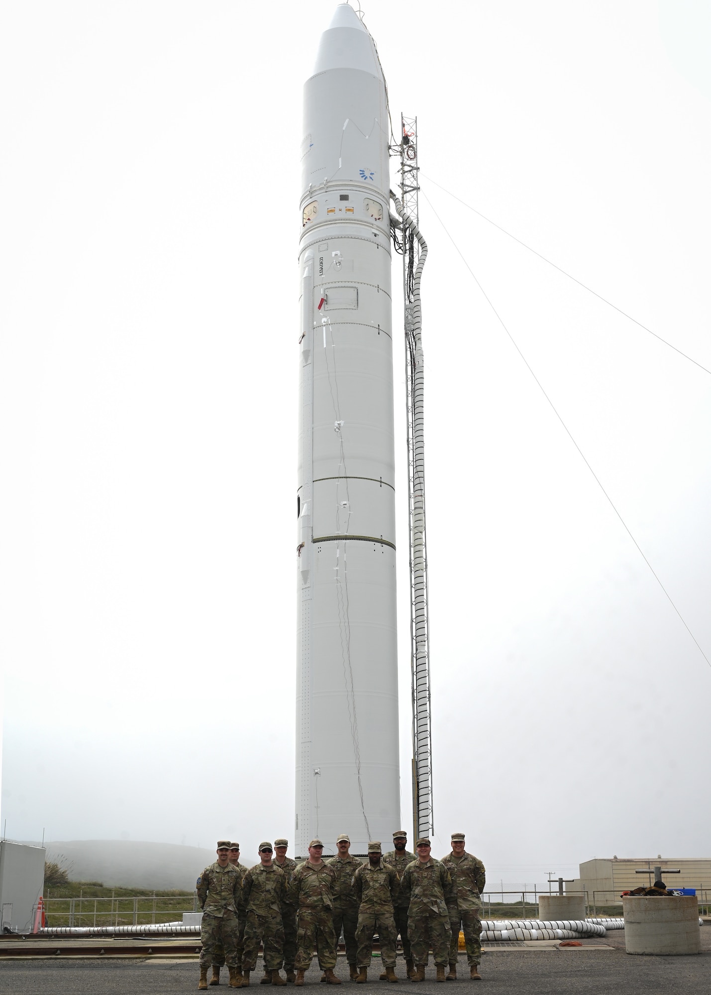 sls military members work in a transporter, big yellow cylinder test motor is pictured, and members are in hard hats