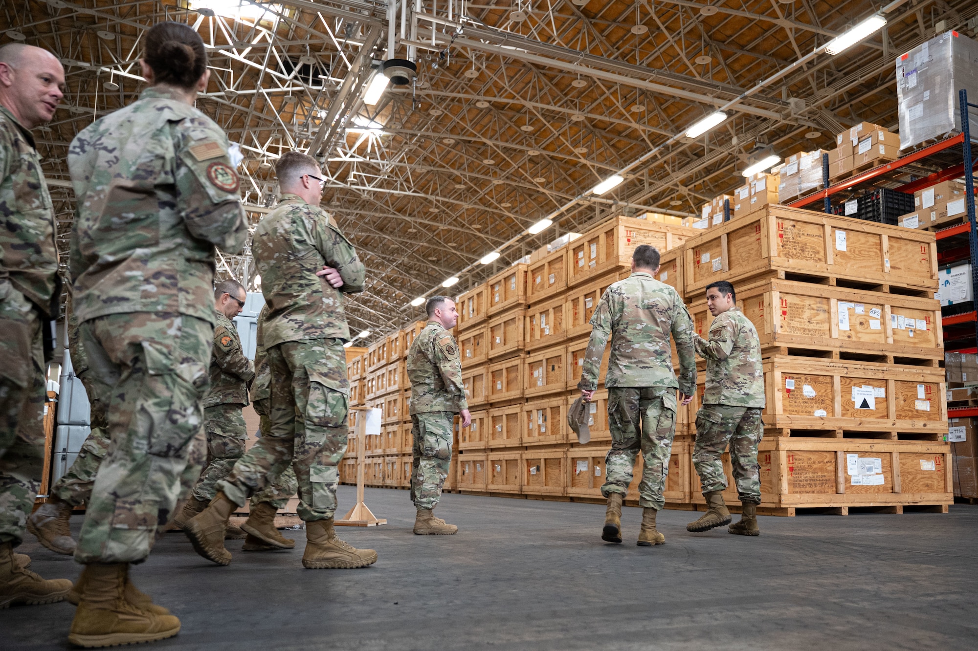 Service members walk through a hangar