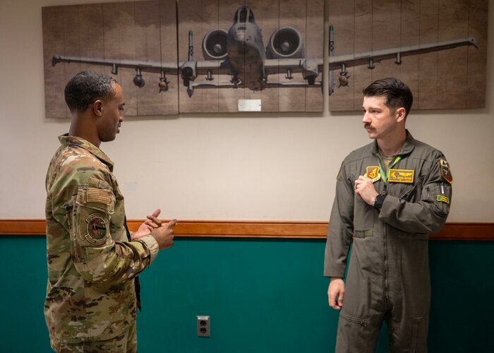 U.S. Air Force Senior Airman Christopher Djedi, 25th Fighter Squadron commander’s support staff, assists a pilot at Osan Air Base, Republic of Korea, April 16, 2025. Djedi ensures accurate performance briefs, orders management, and record maintenance in support of the 51st Fighter Wing’s readiness mission. (U.S. Air Force photo by Senior Airman Sarah Williams)