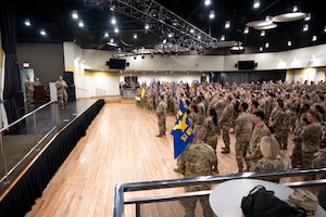 People stand off stage listening to a person talk.