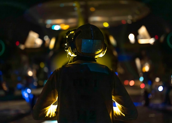 Aviation Boatswain’s Mate (Handling) 3rd Class Austin Howard, of Ottowa, Ill., signals an E-2D Advanced Hawkeye, assigned to the “Black Eagles” of Carrier Airborne Early Warning Squadron (VAW) 113, while it taxis on the flight deck of the Nimitz-class aircraft carrier USS Carl Vinson (CVN 70), Dec. 27, 2024. Vinson, the flagship of Carrier Strike Group ONE, is underway conducting routine operations in the U.S. 7th Fleet area of operations. (U.S. Navy photo by Mass Communication Specialist 2nd Class Isaiah B. Goessl)