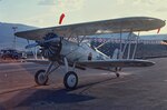 At the September 1967 National Air Races at Stead Air Force Base, west of Reno, Nevada, a restored and flyable F4B-1 stands by a now-empty grandstand, while the red wind sock above the wing shows there is a light wind probably from the southwest. After graduating from college and before joining the Navy, this reviewer spent five-and-a-half months at this rented Air Force base earning his commercial license and instrument rating. I lived in the enlisted barracks and earned pocket money selling programs during the daytime racing activities.