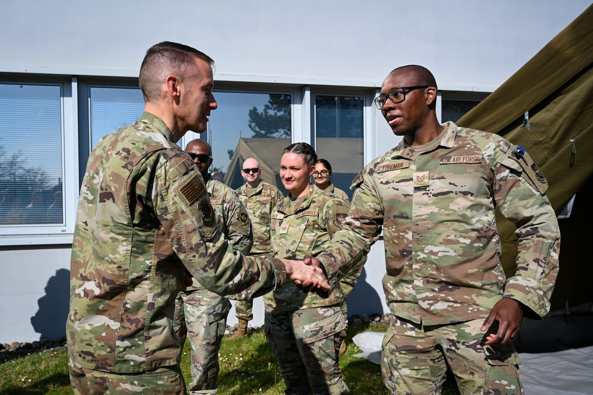 Brig. Gen. Stephen Snelson, left, U.S. Air Force Expeditionary Center commander, coins Tech. Sgt. Elbert Foreman, right, 721st Mobility Support Squadron NCOIC of command and control operations, during an immersion tour on Ramstein Air Base, Germany, April 11, 2025. (U.S. Air Force photo by Staff Sgt. Joshua T. Crossman)