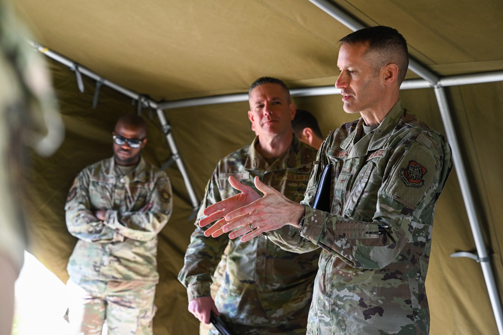 Brig. Gen. Stephen Snelson, right, U.S. Air Force Expeditionary Center commander, talks to members of the 721st Mobility Support Squadron during an immersion tour on Ramstein Air Base, Germany, April 11, 2025.