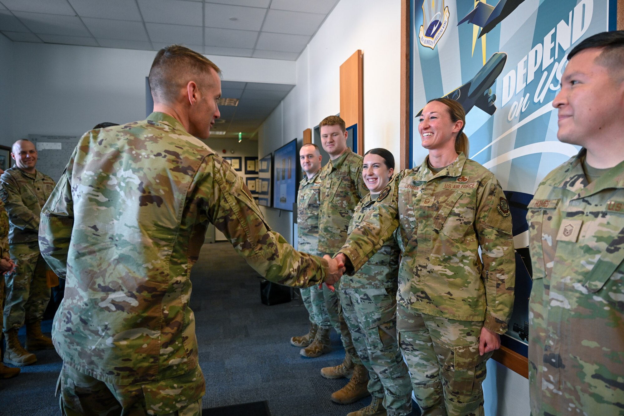 Brig. Gen. Stephen Snelson, left, U.S. Air Force Expeditionary Center commander, coins Master Sgt. Victoria Jensen, right, 721st Aerial Port Squadron fleet services superintendent, at the 521st Air Mobility Operations Wing headquarters building on Ramstein Air Base, Germany, April 11, 2025.