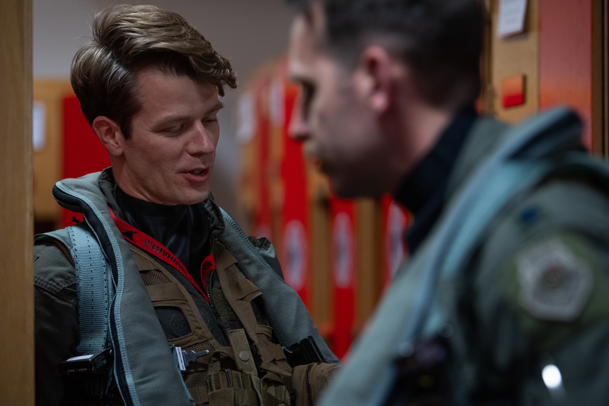 Two U.S. Air Force pilots don flight suits and gear.