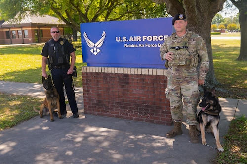 Sgt. Casey Mullins, left, Warner Robins Police Department Proactive Crime Enforcement K-9 Unit training supervisor and Staff Sgt. Brandon Mitchell, right, 78th Security Forces Squadron Military Working Dog kennel master, pose for a quick photo while on patrol, with  Jerry and Faro, their K9 and MWD partners.