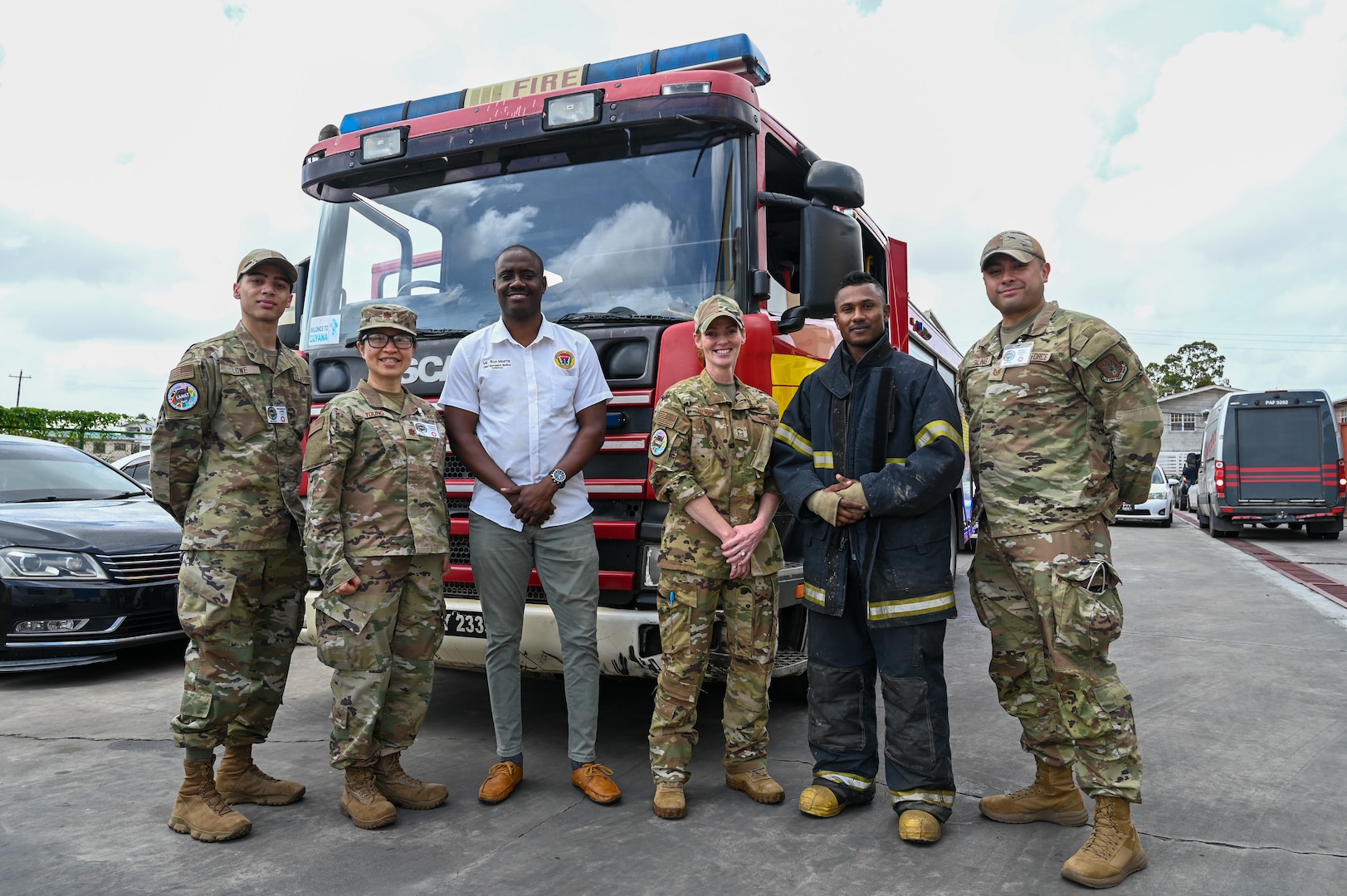 Ron Morris, Guyana Emergency Medical Service chief emergency medical technician, and a Guyana fire fighter pose for a photo with U.S. Air Force members from the 433rd Aeromedical Staging Squadron at the Guyana Fire Station Headquarters on a tour during the LAMAT mission in Georgetown, Guyana, April 2, 2025.