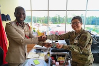 U.S. Air Force Maj. Alisha Young, 433rd Aeromedical Staging Squadron critical care air transport team physician, gifted the Lesser Antilles Medical Assistance Team patch to Gregory Wickham, Guyana Fire Services chief fire officer, during a tour of the Guyana Fire Service Headquarters during the LAMAT mission in Georgetown, Guyana, April 2, 2025.