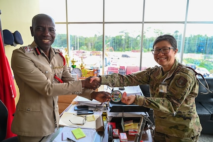 U.S. Air Force Maj. Alisha Young, 433rd Aeromedical Staging Squadron critical care air transport team physician, gifted the Lesser Antilles Medical Assistance Team patch to Gregory Wickham, Guyana Fire Services chief fire officer, during a tour of the Guyana Fire Service Headquarters during the LAMAT mission in Georgetown, Guyana, April 2, 2025.