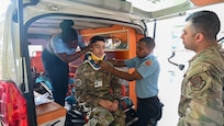 U.S. Air Force Tech. Sgt. Rodrigo Salinas and Senior Airman Brandon Lowe, both medical technicians with the 433rd Aeromedical Staging Squadron, learn how to apply a cervical collar inside an ambulance from Cleveland King, an advanced emergency medical technician training officer with the Guyana Fire and Emergency Medical Service, at the Guyana Fire Service Headquarters in Georgetown, Guyana, April 3, 2025. The training was part of the Lesser Antilles Medical Assistance Team mission, which brings together U.S. military medical personnel and local healthcare professionals from across Latin America and the Caribbean to exchange knowledge and strengthen partnerships.