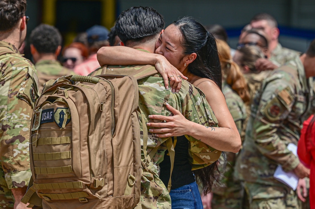 An Airman assigned to the 19th Airlift Wing embraces his family during a redeployment at Little Rock Air Force Base, Arkansas, April 11, 2025. Team Little Rock also contributed to base defense operations by supporting security measures and participating in integrated force protection efforts.