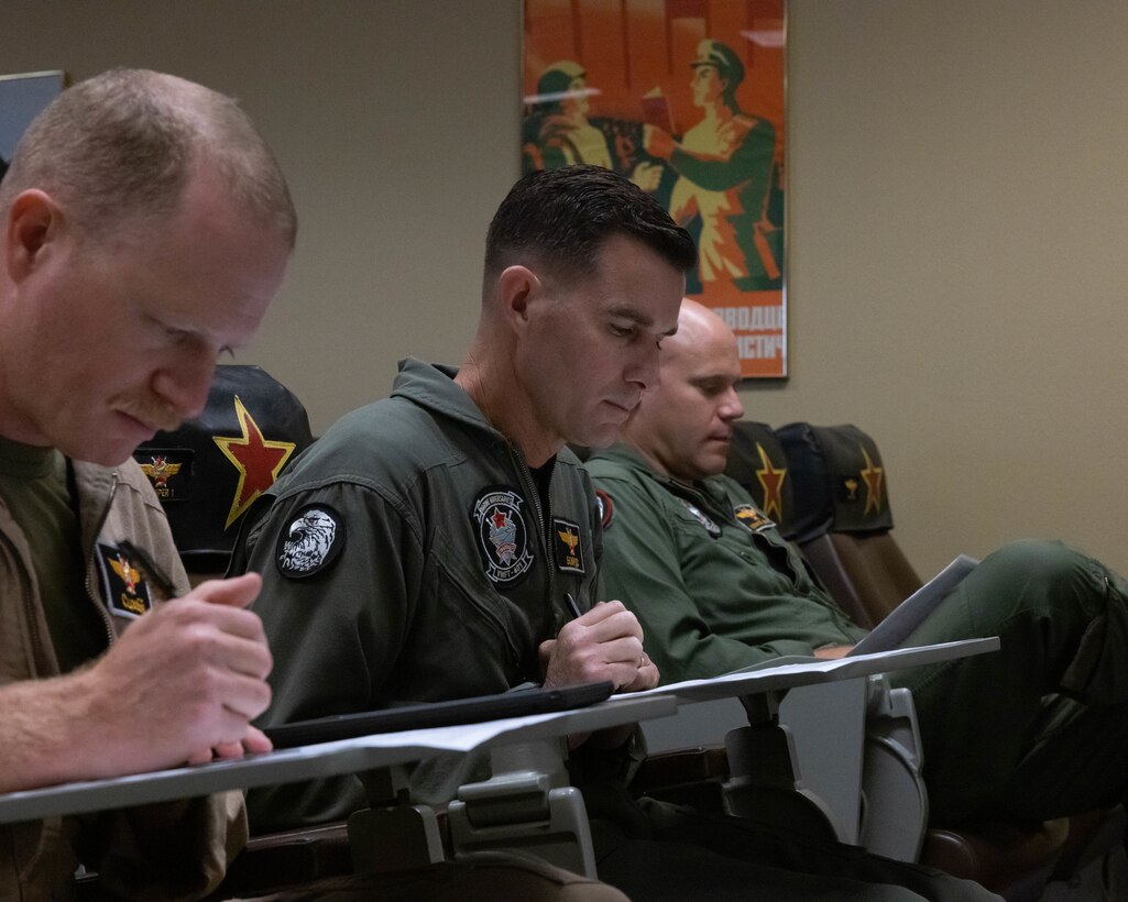 U.S. Marines from various units in the Marine Corps participate in a flight brief given by Lt. Col. Michael Webb, executive officer, Marine Fighter Training Squadron 401 (VMFT-401), Marine Aircraft Group 41, 4th Marine Aircraft Wing, at Marine Corps Air Station Yuma, Arizona, Oct. 28, 2022. VMFT-401 is the only adversary squadron with the mission to act as the opposing force in simulated air combat. (U.S. Marine Corps photo by Lance Cpl. Jade Venegas)