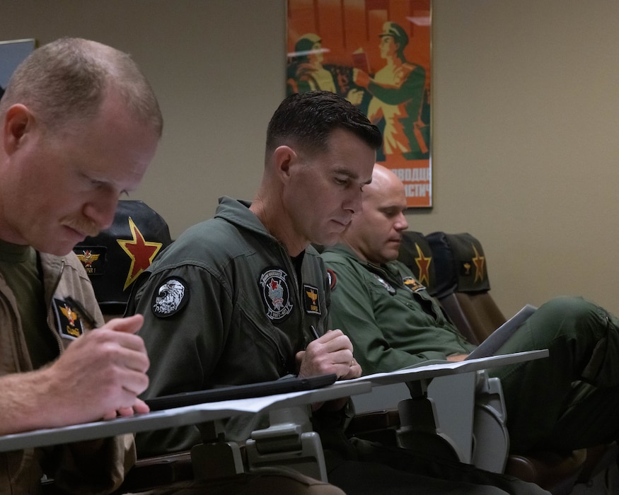U.S. Marines from various units in the Marine Corps participate in a flight brief given by Lt. Col. Michael Webb, executive officer, Marine Fighter Training Squadron 401 (VMFT-401), Marine Aircraft Group 41, 4th Marine Aircraft Wing, at Marine Corps Air Station Yuma, Arizona, Oct. 28, 2022. VMFT-401 is the only adversary squadron with the mission to act as the opposing force in simulated air combat. (U.S. Marine Corps photo by Lance Cpl. Jade Venegas)